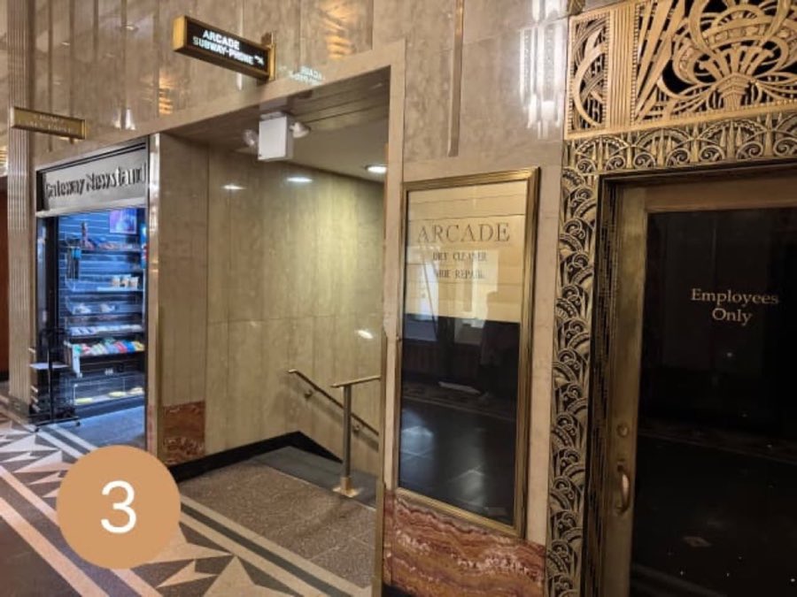 Marble corridor with a sign reading ARCADE, SUBWAY, PHONE near a stairwell