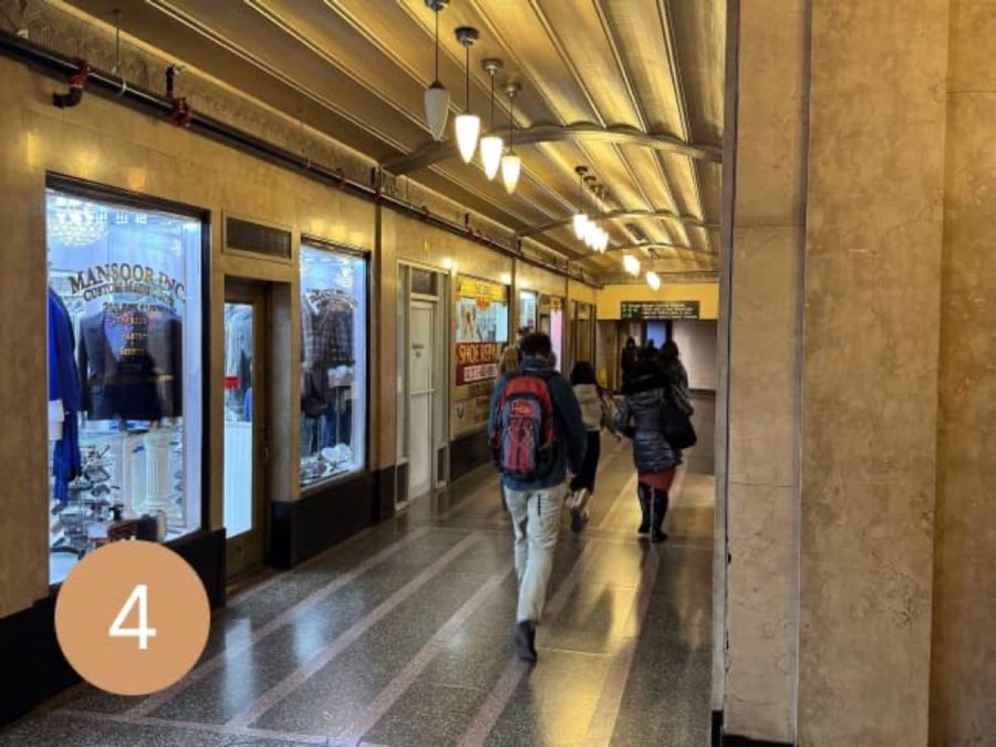 Gilded, vaulted Art Deco arcade ceiling with storefronts along a marble corridor