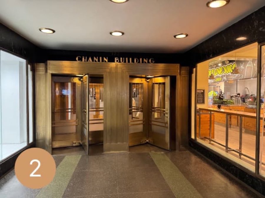 Brass revolving doors beneath a sign reading CHANIN BUILDING at the main 42nd Street entrance