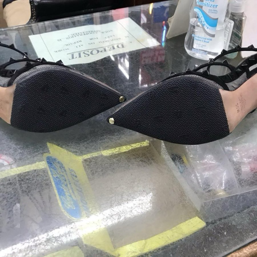 Brown leather derby shoes, newly resoled, resting soles-up on the counter