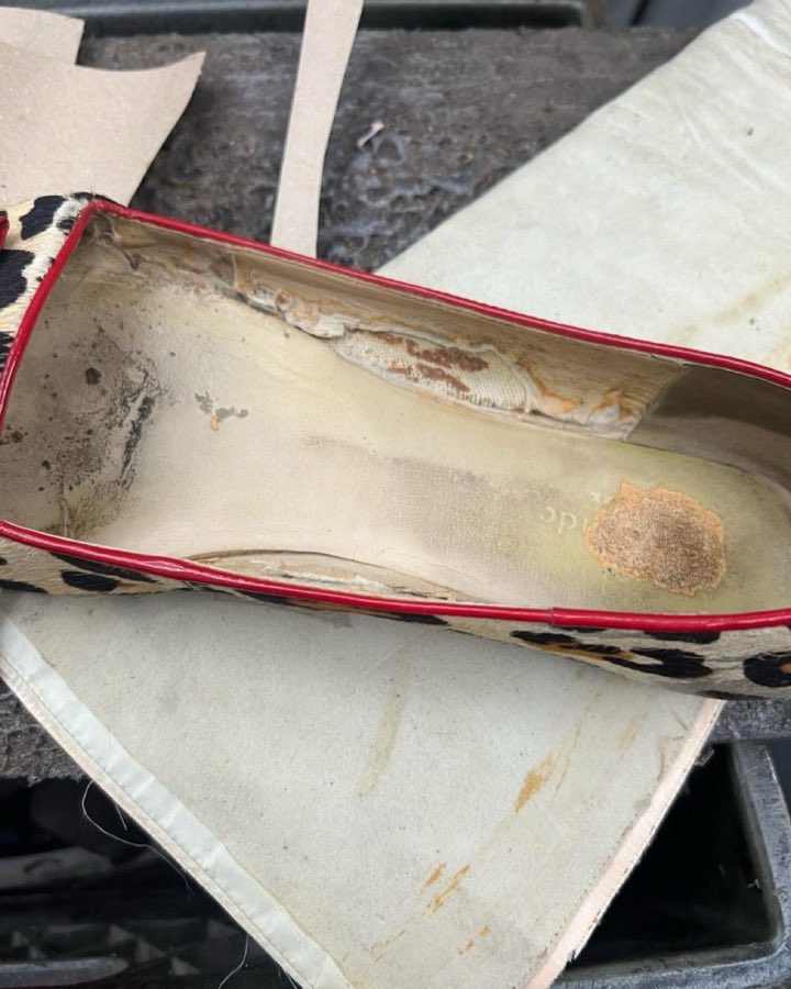 Interior view of a leopard-print flat showing the worn insole before repair