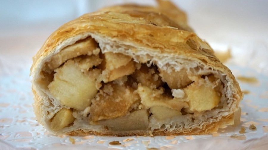 Cross-section of a hand-made apple strudel slice, showing layered pastry and apple filling