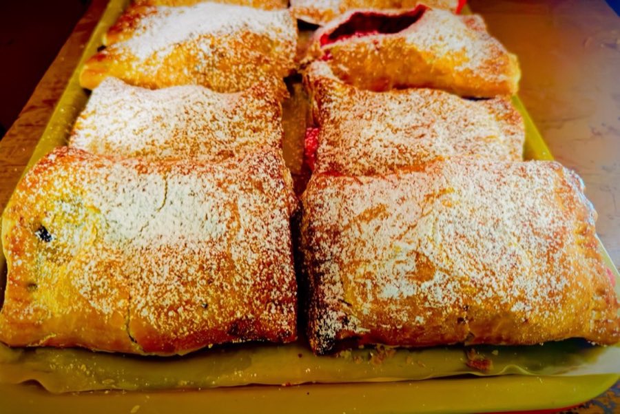 Tray of fruit-filled pastry pockets dusted with powdered sugar