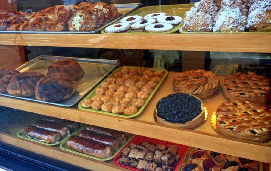 Bakery display case filled with croissants, jam-filled cookies, and powdered-sugar pastries at Andre's Bakery