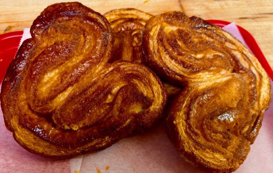 Two glazed palmier butterfly pastries with caramelized sugar shell