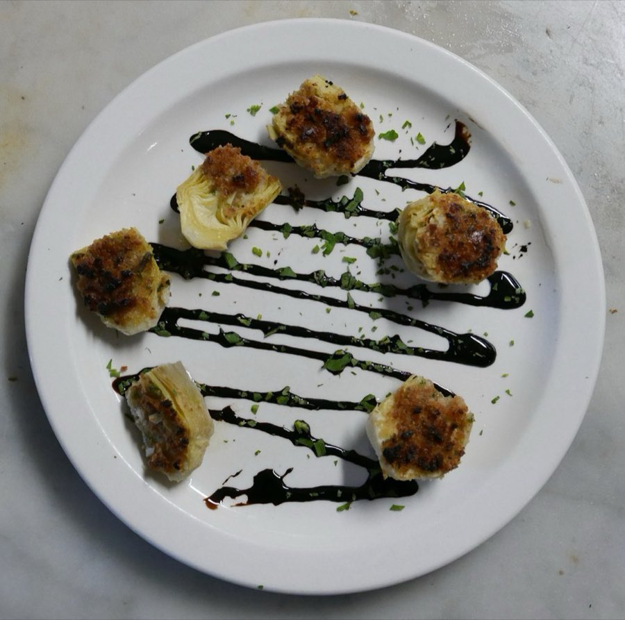 A plated appetizer finished with a balsamic drizzle