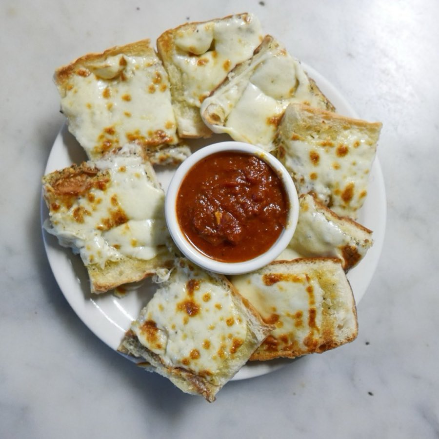 Garlic bread squares served with a side of marinara sauce