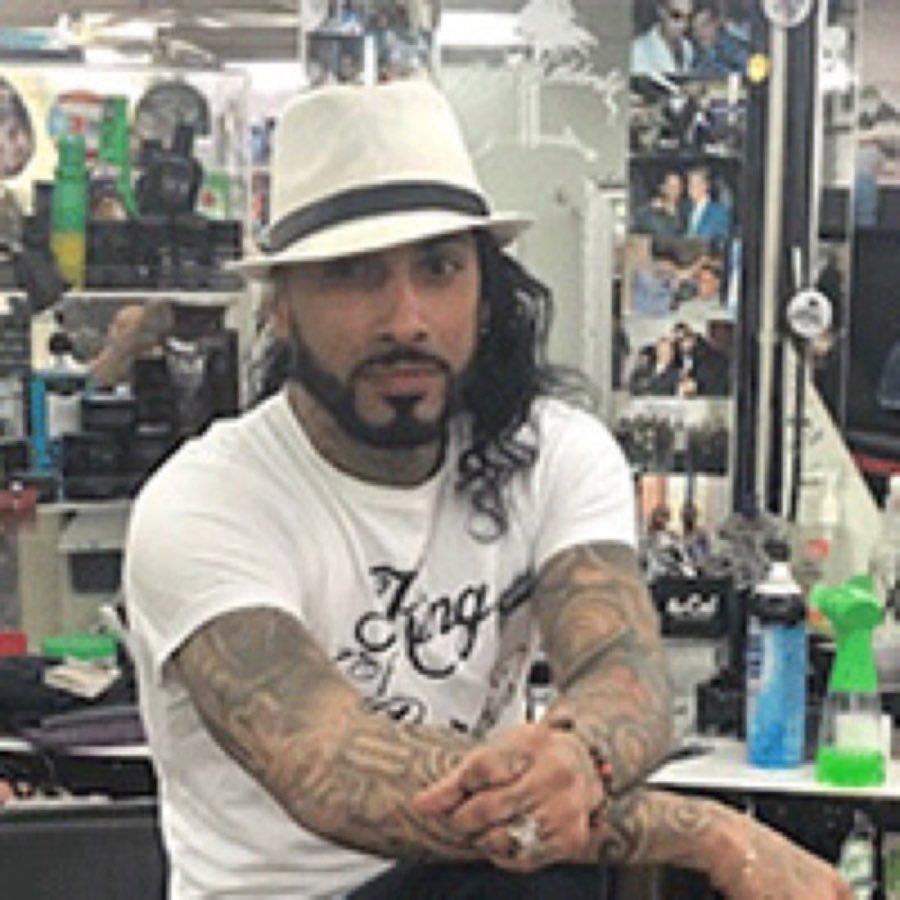 Portrait of barber Joel in the shop, visibly tattooed