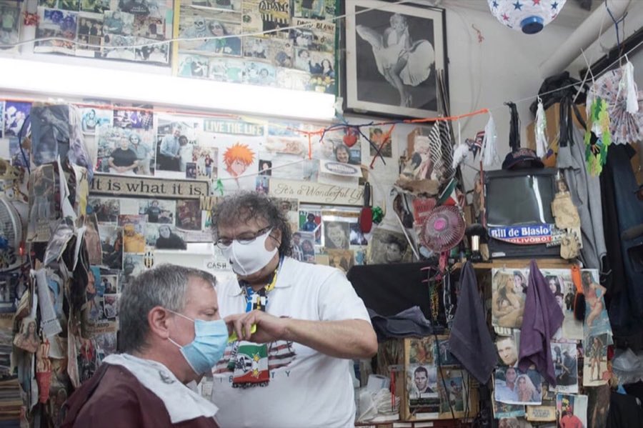 Interior of the shop showing walls completely covered floor to ceiling in decades of taped-up photographs and memorabilia