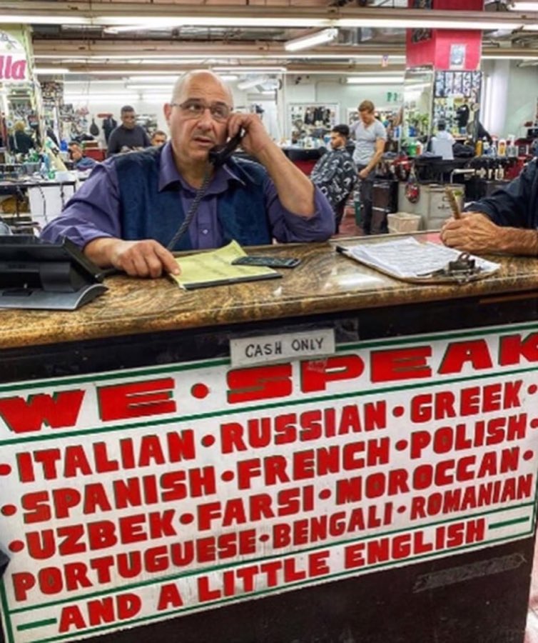 The shop's hand-painted front-desk sign reading WE SPEAK Italian, Russian, Greek, Spanish, French, Polish, Uzbek, Farsi, Moroccan, Portuguese, Bengali, Romanian, and a little English, with a Cash Only notice