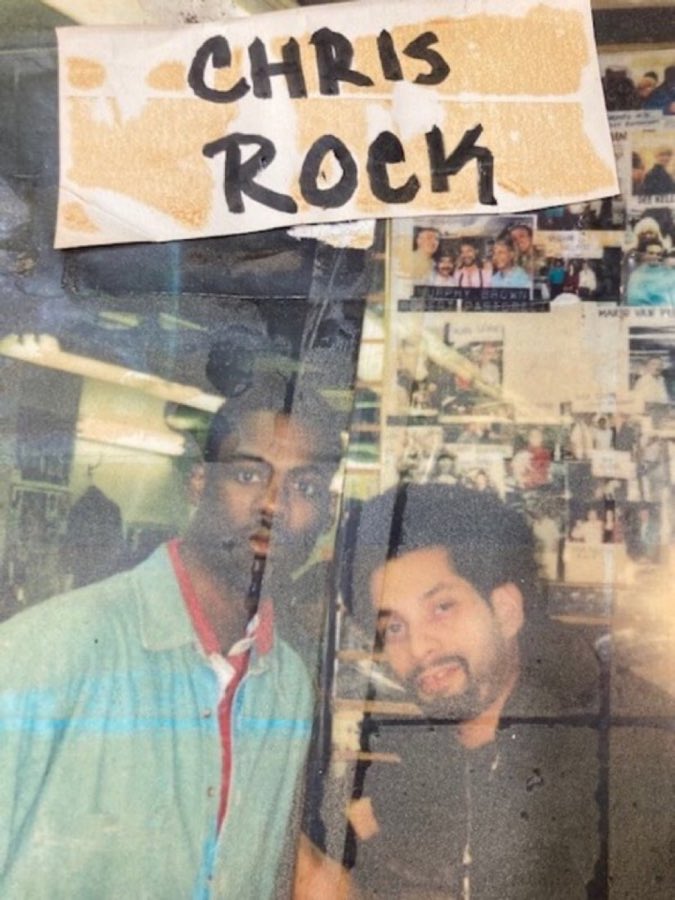 Photo from the shop wall labeled Chris Rock, taped up alongside other Polaroid-style photos