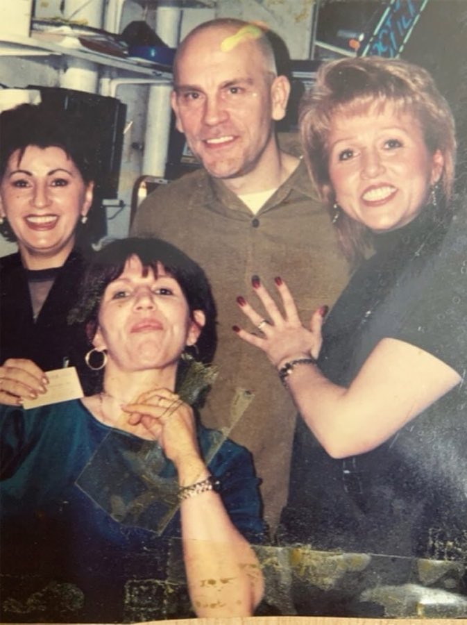 Photo from the shop wall of a customer identified as John Malkovich with a barber