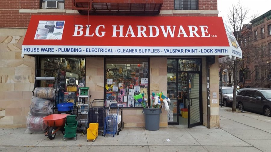 BLG Hardware storefront at 439 Malcolm X Blvd, with a red awning reading BLG HARDWARE LLC and a packed display window of tools and supplies