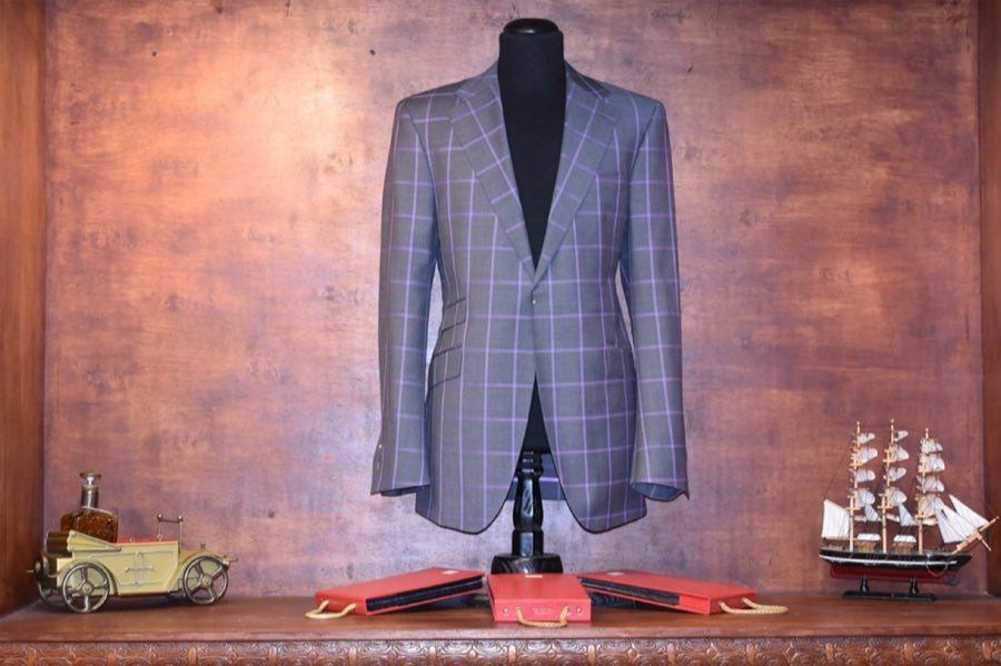 Blue checked jacket on a mannequin beside a model ship on the counter