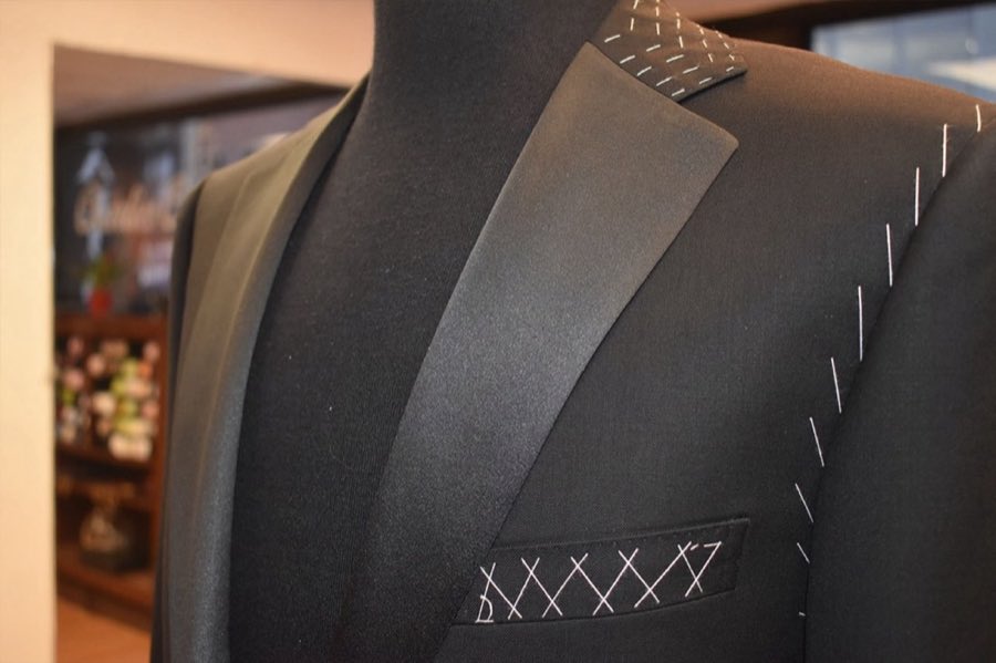 Close-up of a grey suit jacket lapel with hand-stitched detailing
