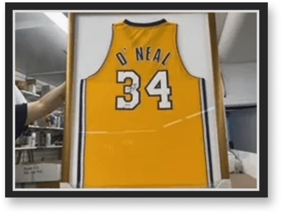 A signed yellow Lakers jersey, number 34, O'Neal, custom-framed and displayed at the shop