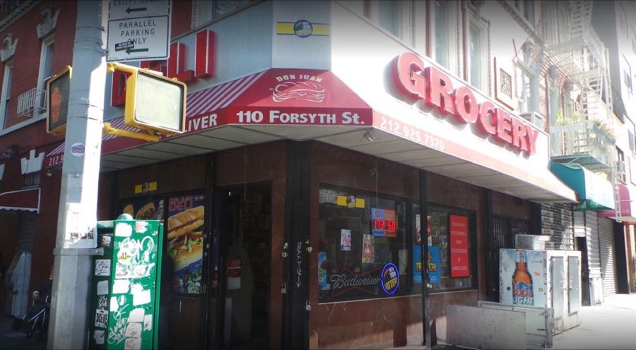 Don Juan Deli and Grocery corner storefront at 110 Forsyth Street, with red DELI and GROCERY awning lettering and candy-stripe awning trim