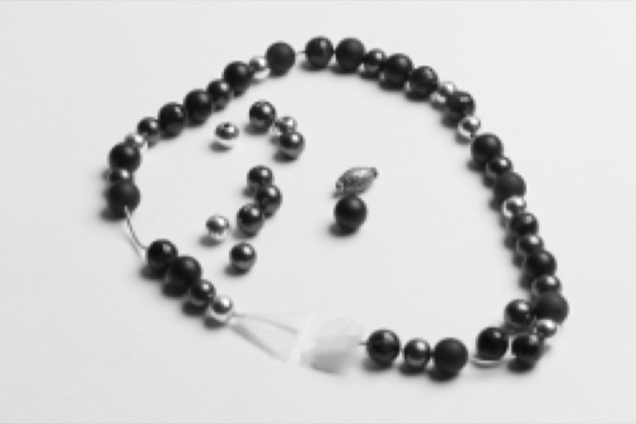 A beaded necklace before restringing and cleaning