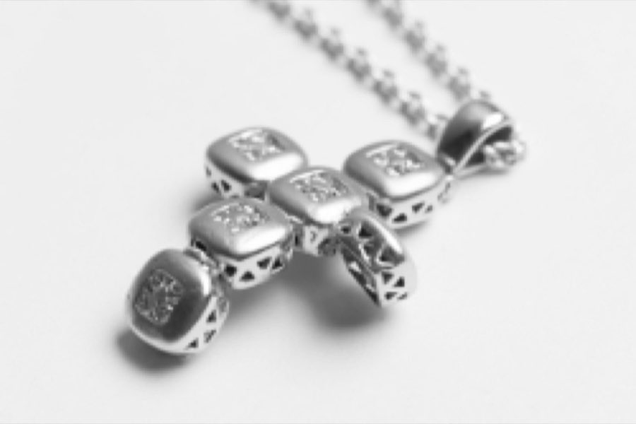 A cross-style pendant chain before cleaning and repair
