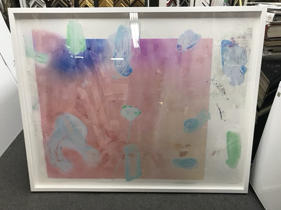 An abstract watercolor artwork mounted and framed in a simple white float frame
