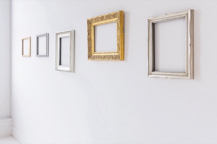 A row of frame samples, from plain wood to ornate gold, on display at the shop