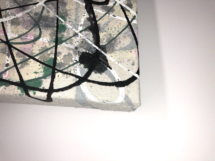 Close-up of a raw canvas corner being stretched over a wooden frame