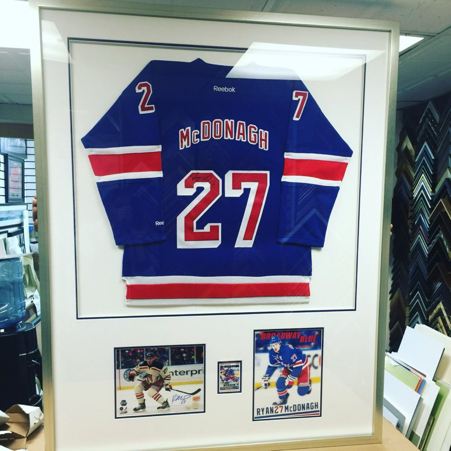 A signed New York Rangers hockey jersey mounted in a large custom shadow box frame
