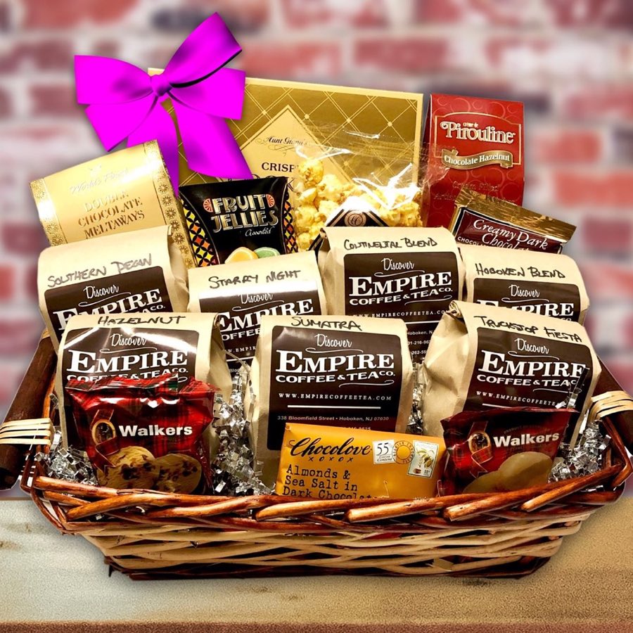 A wicker gift basket filled with Empire coffee bags labeled Southern Pecan, Starry Night, Continental Blend, Hoboken Blend, Sumatra, Truckstop Fiesta, and Hazelnut, along with Walkers shortbread, Chocolove chocolate, and Pirouline wafers