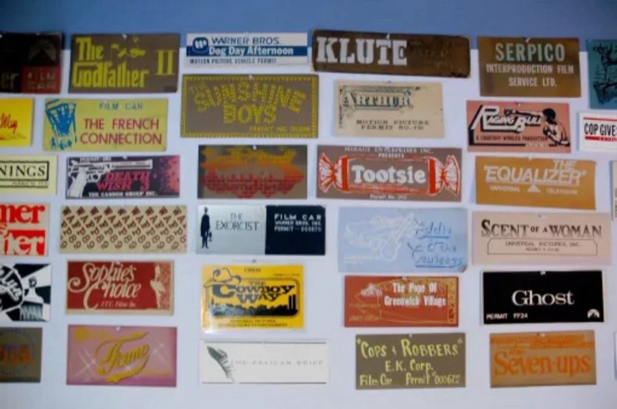 A wall covered in framed film and television production permit placards, including The Godfather II, Raging Bull, Klute, Serpico, The French Connection, Tootsie, Ghost, Sophie's Choice, and Scent of a Woman
