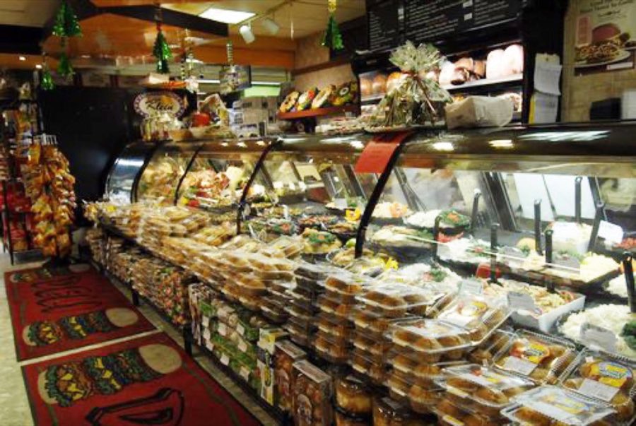 Wide view of the deli counter with staff serving prepared foods