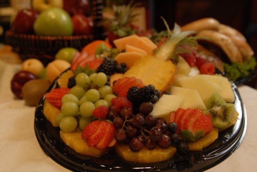 Fruit platter with fresh fruit, berries, and melon artfully arranged in a basket