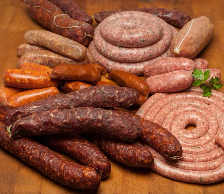 A large spread of house-made sausage links and coils, including fresh, smoked, and dry-cured varieties