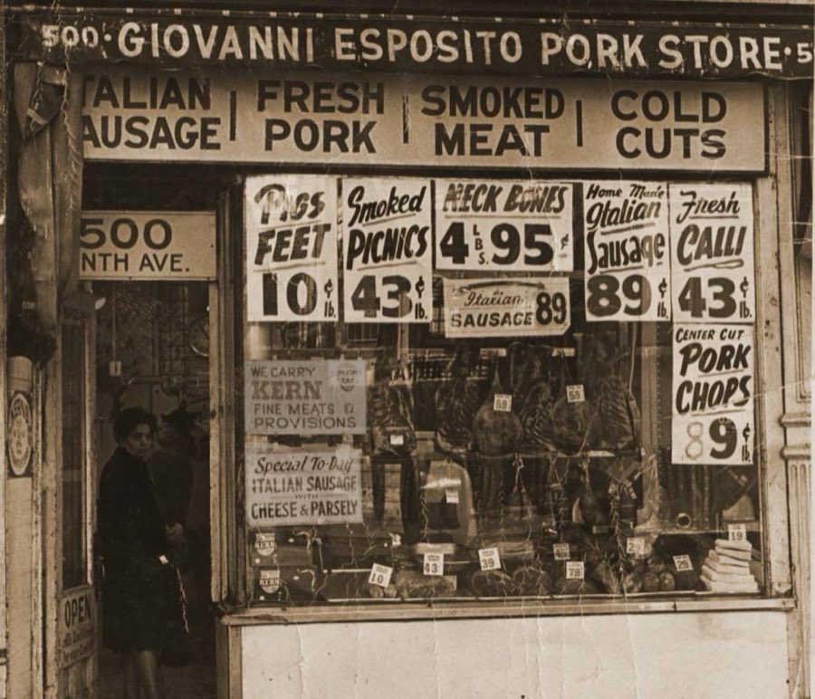 Vintage photograph of the original Giovanni Esposito Pork Store storefront, with hand-lettered price signs for pigs feet, smoked picnics, and homemade Italian sausage