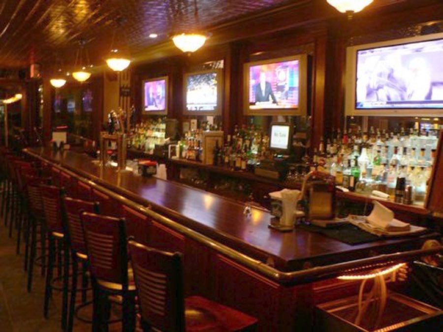 Jake's Saloon long wooden bar with televisions above it