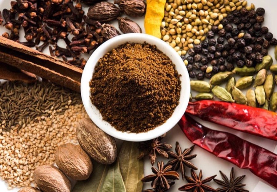Flat-lay of loose spice bags: turmeric, paprika, cardamom pods, black pepper, dried chilies, star anise, nutmeg and cinnamon sticks
