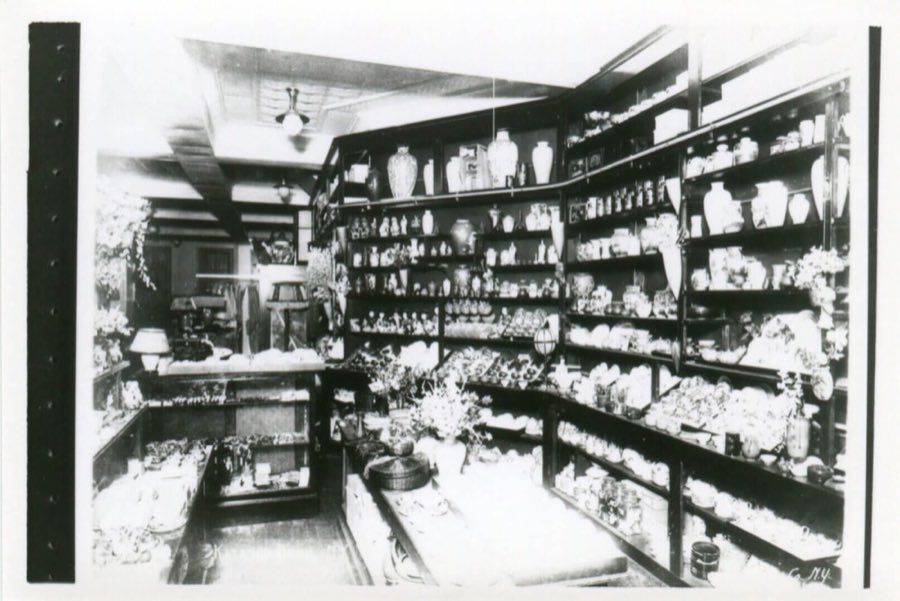 Inside the historic Katagiri shop: dark wooden shelves crowded with Japanese vases, ceramics and pottery, with flowers on the display tables.