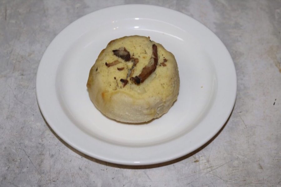 A round baked mushroom and potato knish, on a white plate