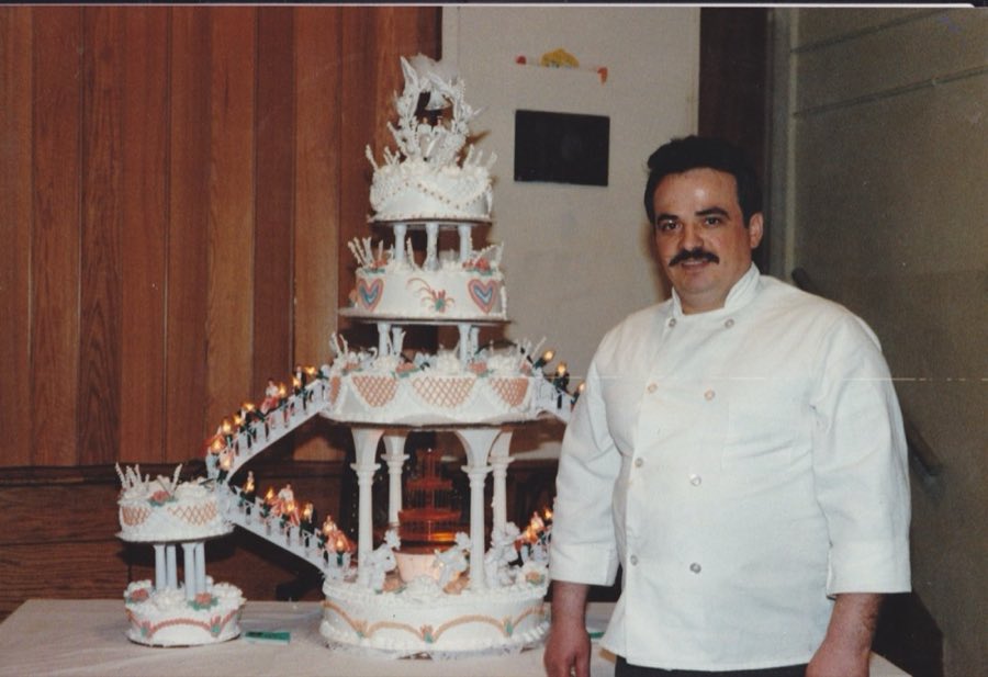 George standing beside a tiered wedding cake