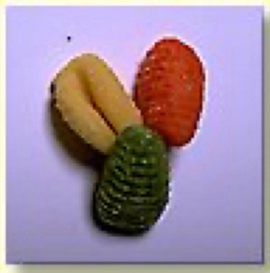 Three gnocchi in plain, tomato, and spinach dough on a red background