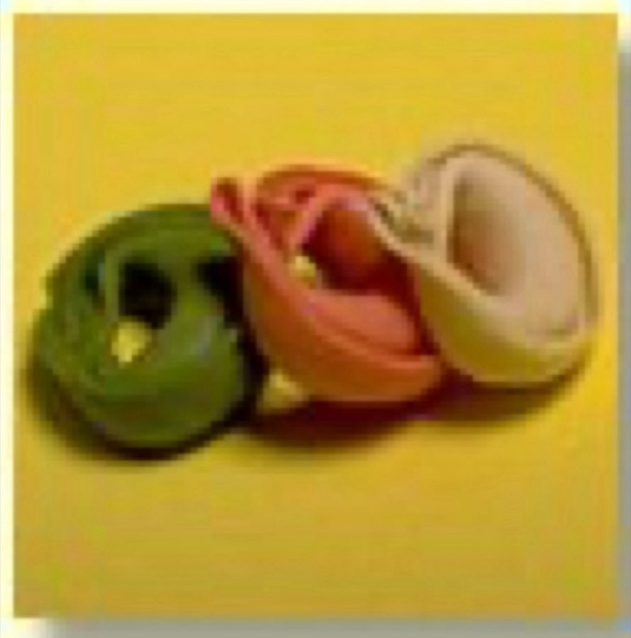 Ring-shaped tortellini in three colors on a yellow background