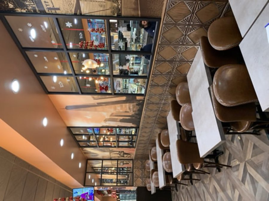 Wide interior view of the dining room with marble tables and pendant lighting