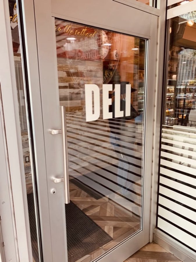 Stage Door Deli storefront glass door with DELI lettering