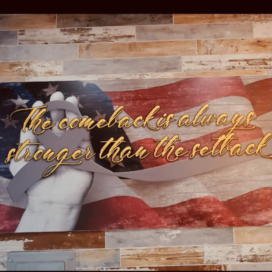 Wall mural with typographic quote and American flag imagery near the seating area