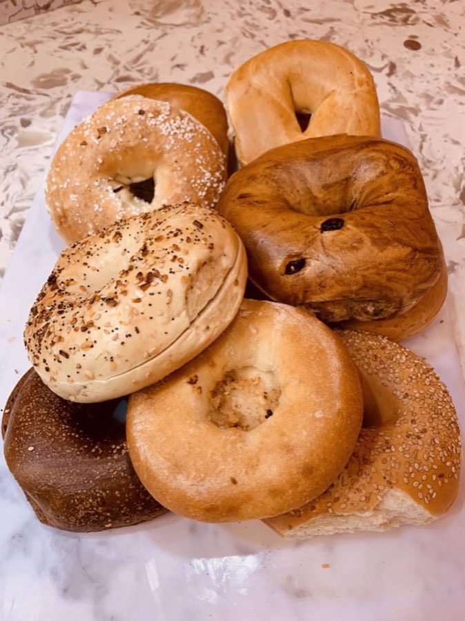 Assorted fresh bagels stacked on a marble counter
