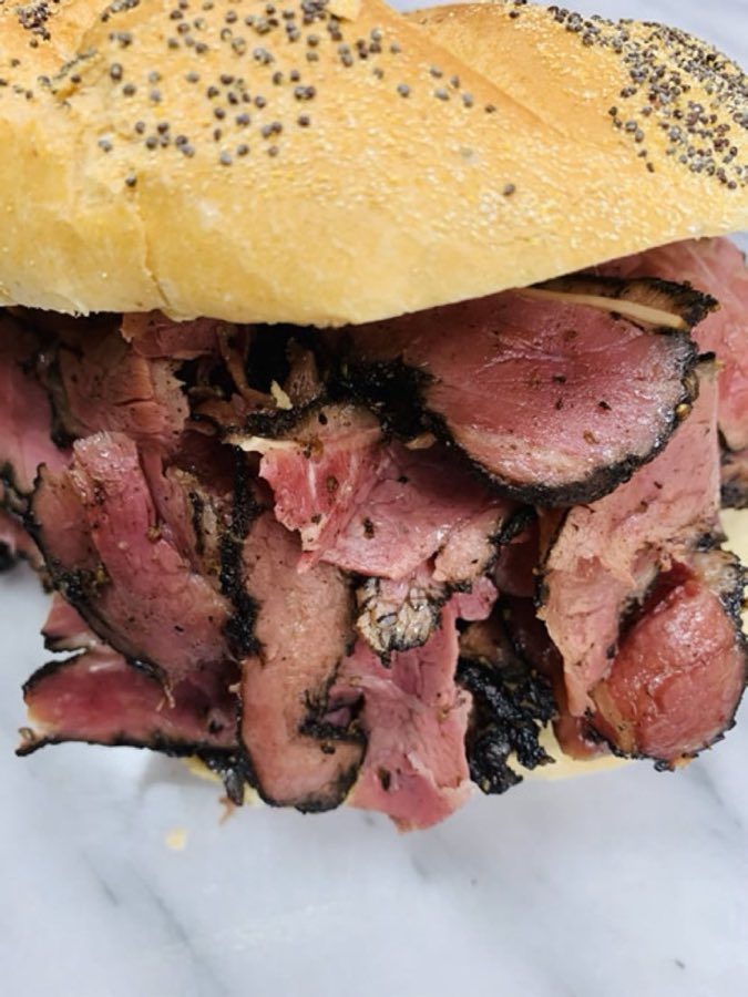 Sliced pastrami piled on a sesame bagel