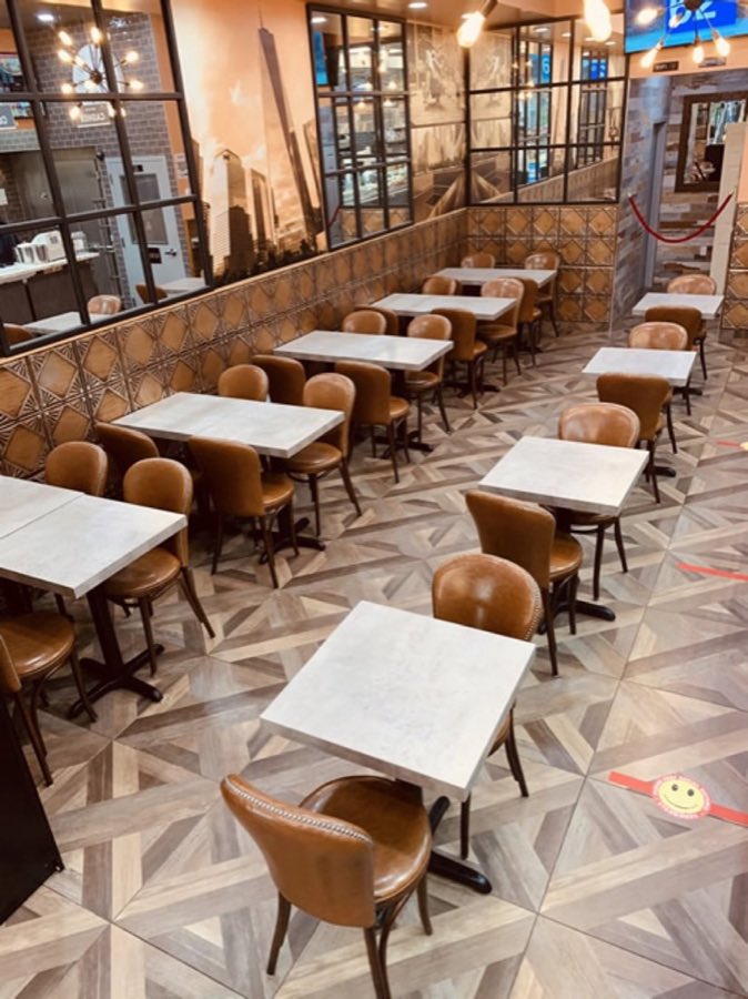 Stage Door Deli's dining room: marble-top tables, wood-and-leather chairs, and warm pendant lighting