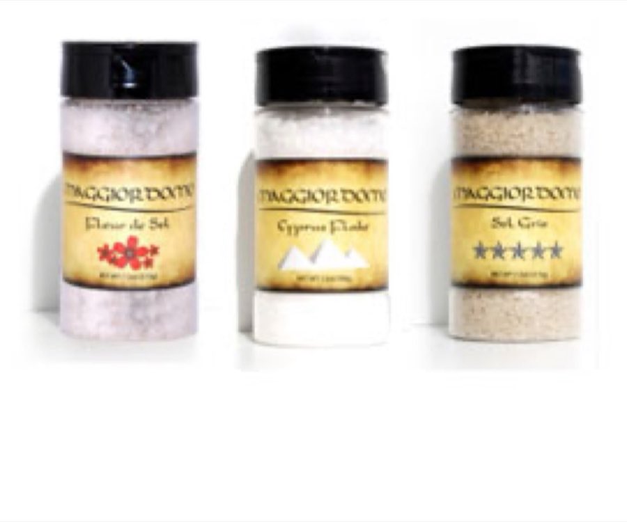 Three jars of Maggiordomo finishing salts — Fleur de Sel, Cyprus Flake, and Sel Gris — with parchment labels and black caps on a white background