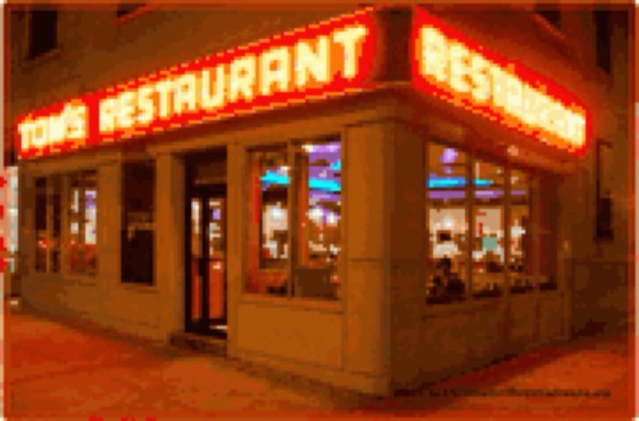 Tom's Restaurant's red neon corner sign glowing at night above the lit storefront windows