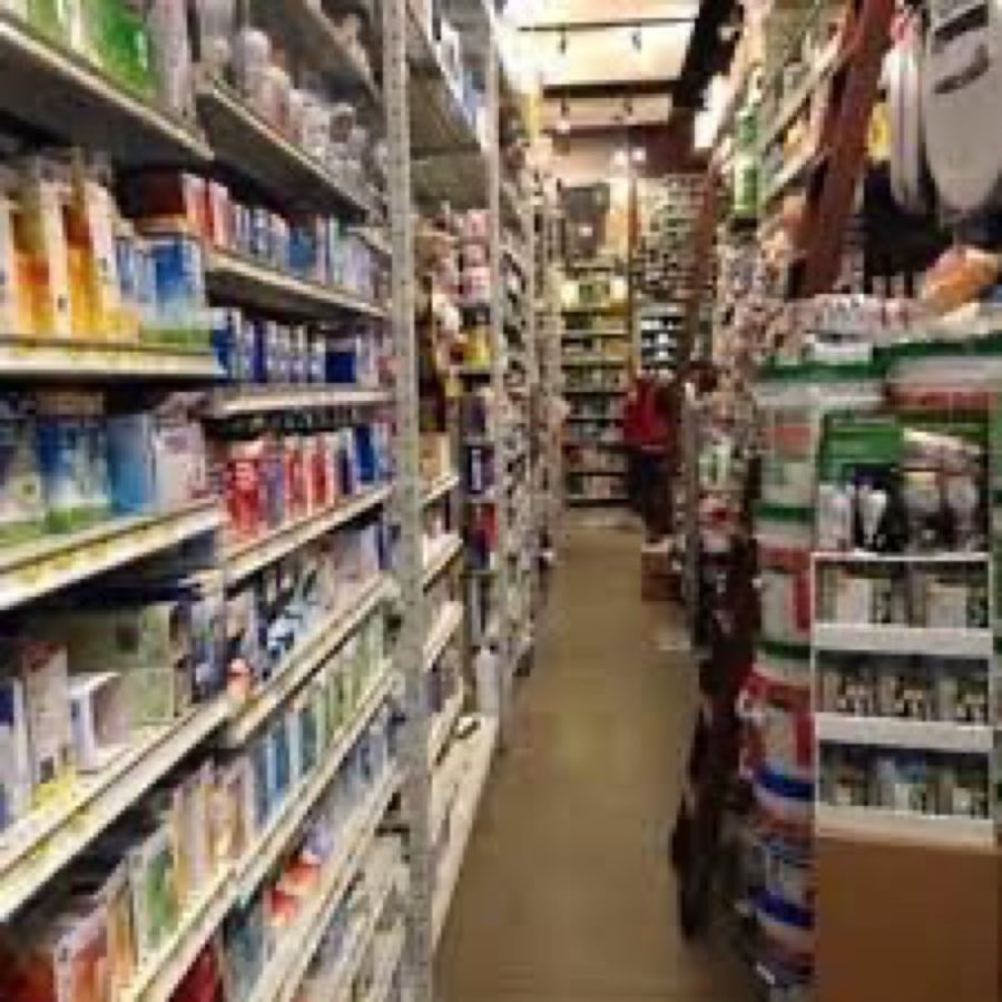 An aisle inside Tribeca Paint stocked with hardware and household supplies