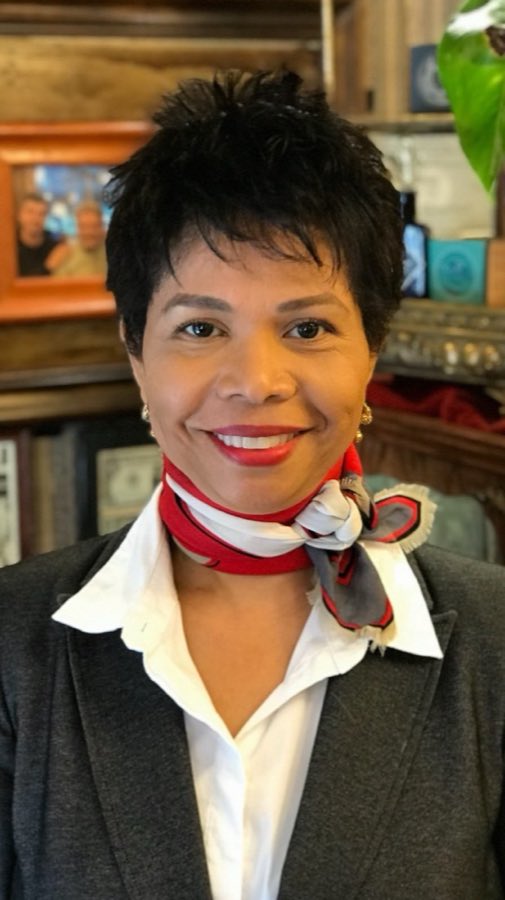 Maru, York Barbershop stylist, wearing a red and grey patterned scarf
